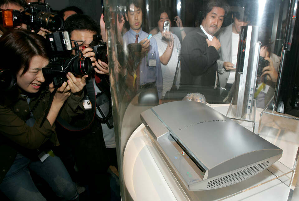 En mängd pressfotografer tar bilder på ett Playstation 3, som placerats i en glasmonter