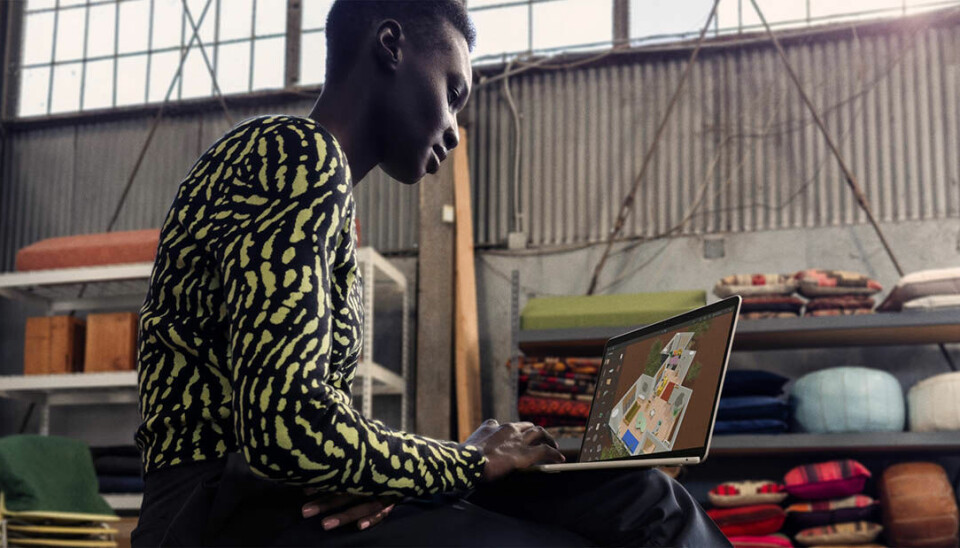 En man sitter med Apples nya dator Macbook Air M3 i knät.