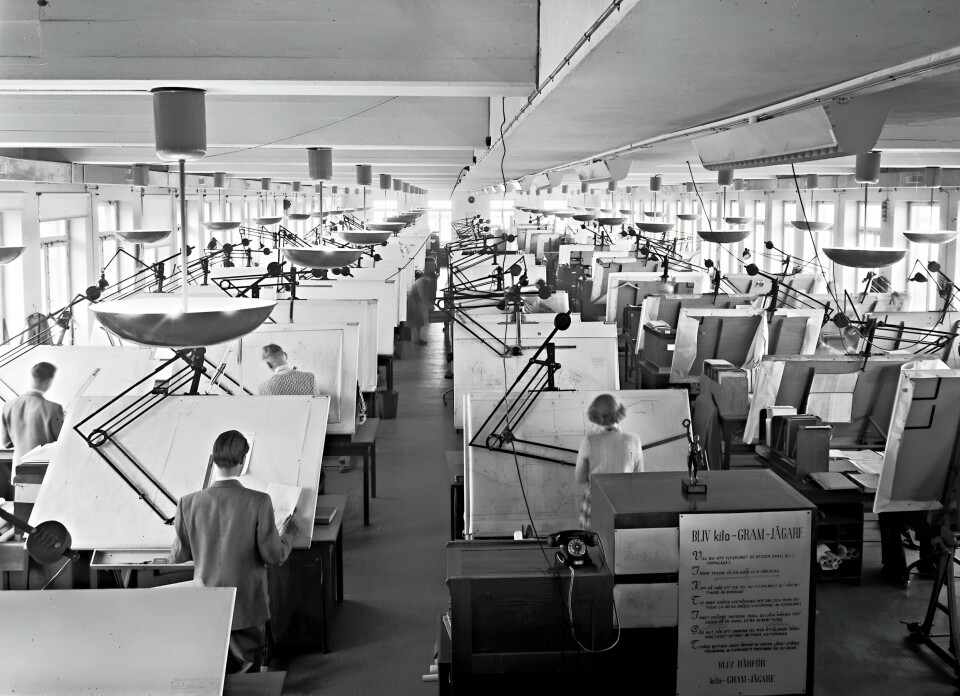 Svartvit bild som visar rader av ritningsställ och Saab-anställda som konstruerar ritningar