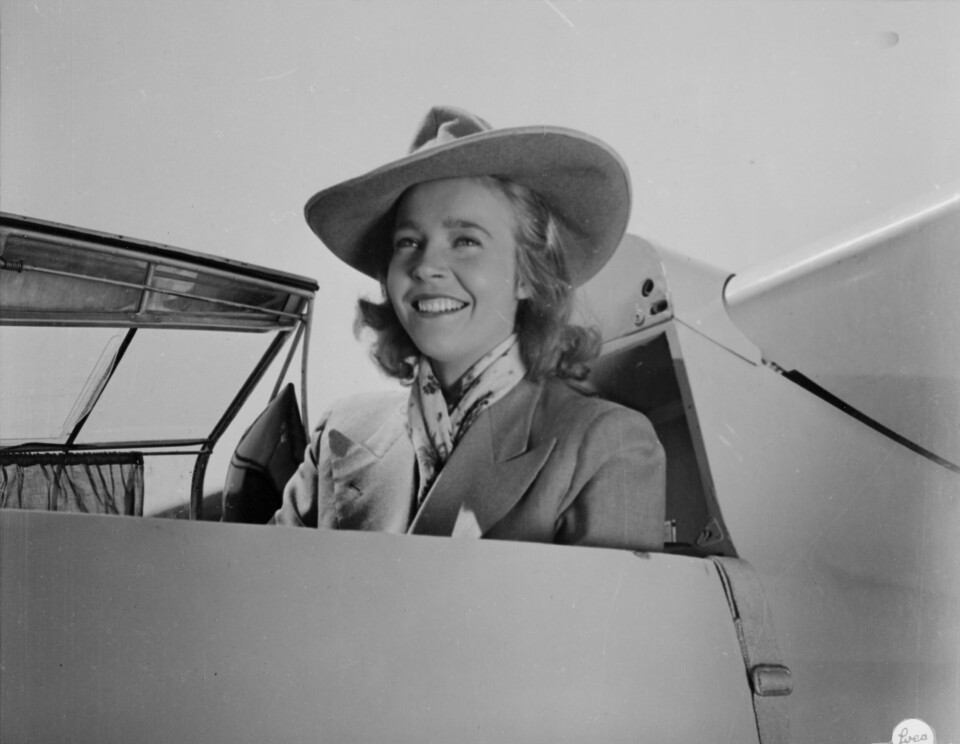 Alice Babs iklädd en bredbrättad hatt, sittande i cockpit till ett segelflygplan