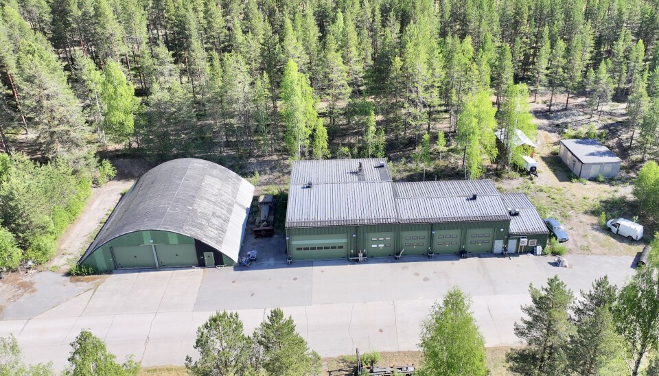 Det ingår även fem flyghangarer och en rejäl verkstad. Två grönmålade byggnader fotograferade med drönare, en halvcirkelformad flyghangar och en verkstad med flera portar för fordon.