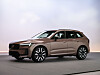 En bronsfärgad Volvo SUV parkerad i en minimalistisk studio.