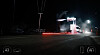 En vit Tesla Semi-lastbil kör genom ett testområde på natten under en sprayanordning med röd rök på marken.