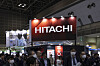 En stor belyst röd Hitachi-skylt ovanför en folkmassa på en teknikmässa i Tokyo Big Sight.