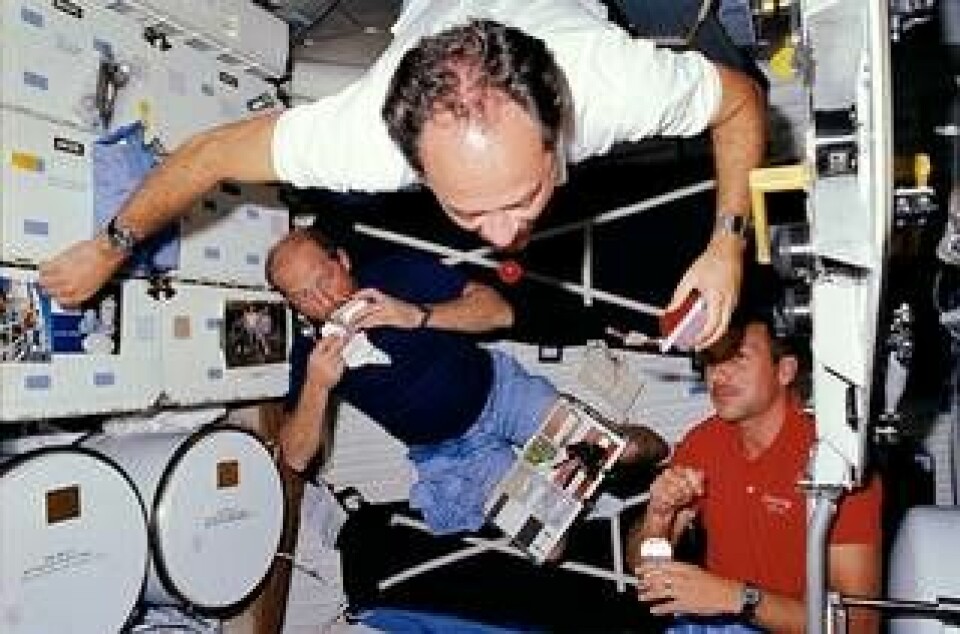 John Lounge försöker fånga en röd vätska i tyngdlöst tillstånd ombord på rymdfärjan Discovery år 1988. Frederick Hauck till vänster och David Hilmers tittar på. Foto: Nasa