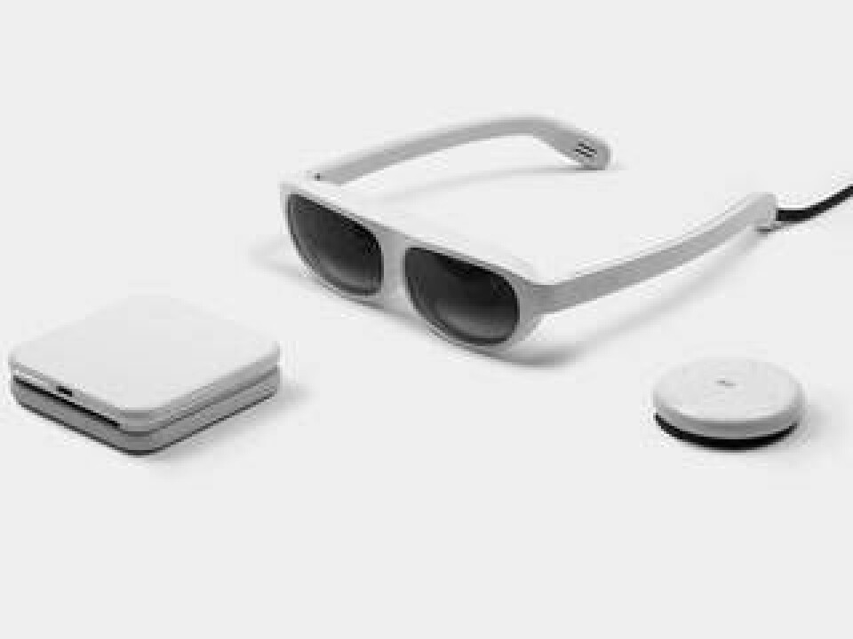 Nreal Light är ett par augmented reality-glasögon. Processor och batteri sitter i en extern enhet. Den runda enheten till höger fungerar som handkontroll. Foto: Nreal