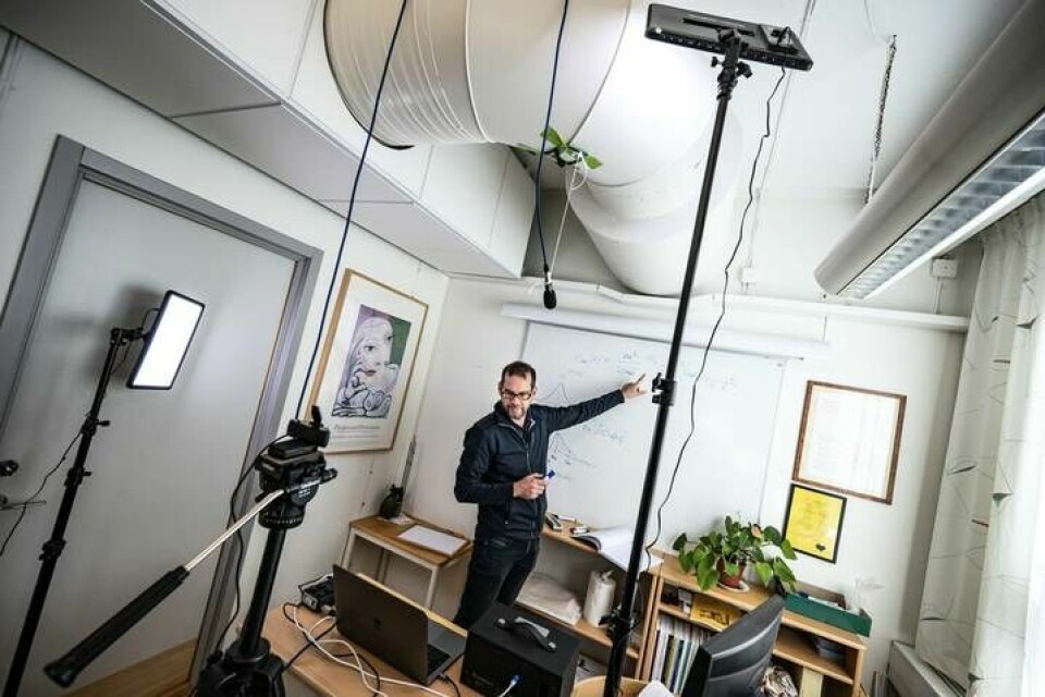 Universitetslektor Kristofer Modig har gjort om sitt arbetsrum på Kemicentrum i Lund till en liten studio. Han kan ha föreläsning för 100 studenter på en gång, men ser bara 18 av dem åt gången på små bilder på dataskärmen. Foto: Foto: Johan Nilsson/TT