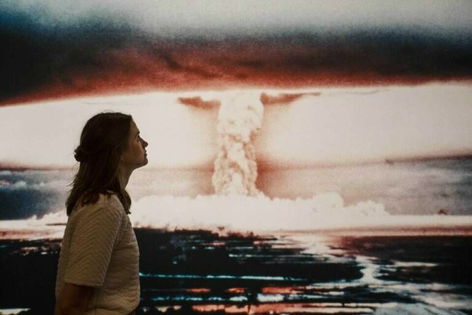 En människa framför en bild av ett svampmoln, orsakat av en atombomb. Foto: Rick Findler/REX