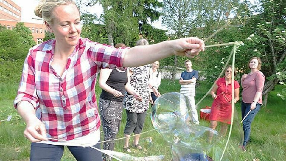 Helena Wirén testar hur stora såpbubblor man kan göra med en egen konstruktion. Foto: Tommy Harnesk