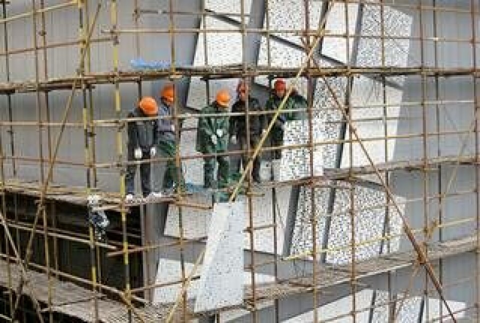 Arbetare monterar stansade stålplattor som ska pryda paviljonens fasad. Foto: Svenska paviljongen på Shanghai Expo 2010