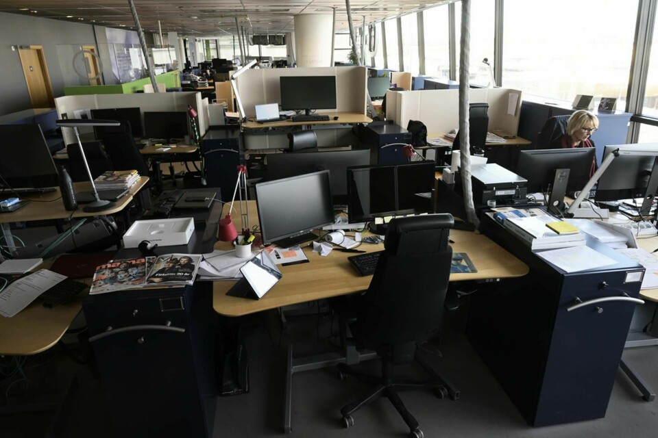 En ensam medarbetare jobbar på ett i övrigt öde kontor efter att medarbetarna valt att jobba hemma på distans. Foto: Fredrik Sandberg/TT