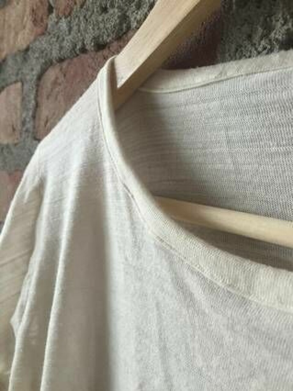 Vit tröja tillverkad av Renewcells textilmassa, som har spunnits till ny tråd och sedan stickats. Ett projekt från Högskolan i Borås. Bomullsråvaran kom från gamla jeans. Foto: Renewcell