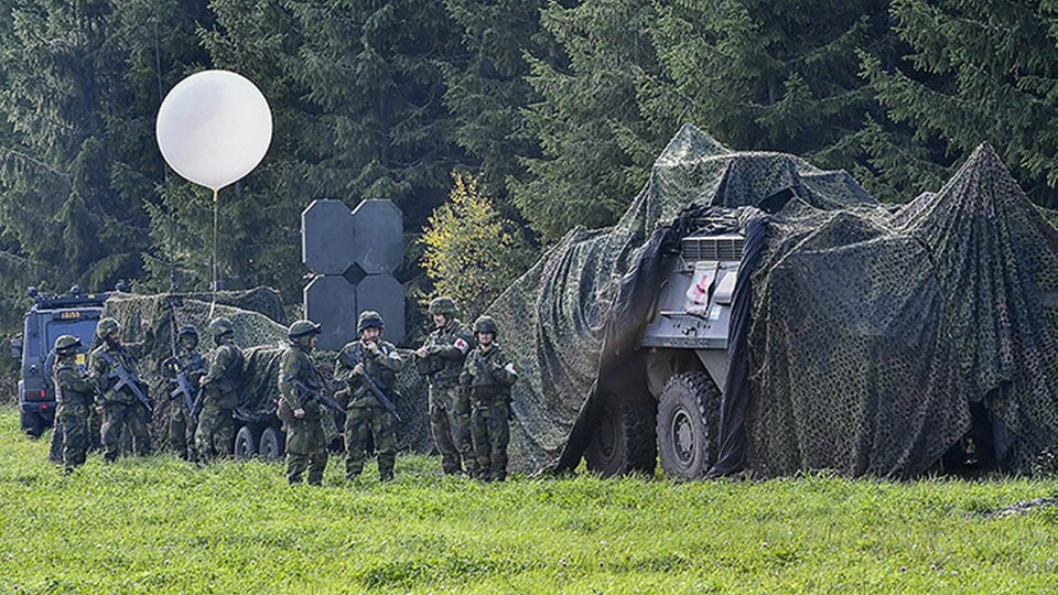 Militärfordon med skyddsnät och soldater under försvarsövningen Aurora 17. Foto: Jonas Ekströmer / TT Militärfordon med skyddsnät och soldater under försvarsövningen Aurora 17. Foto: Jonas Ekströmer / TT