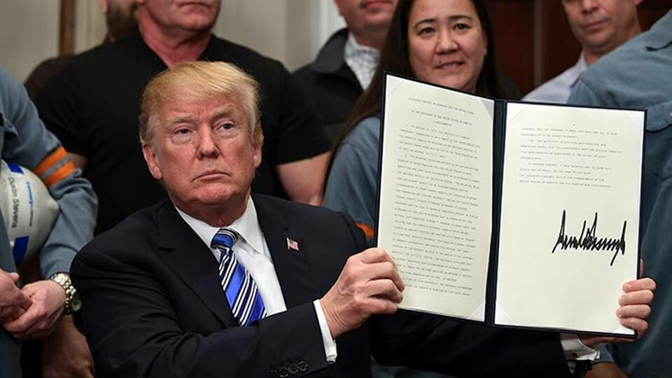 Omgiven av en grupp stålarbetare i jobbkläder och med skyddshjälm har USA:s president Donald Trump undertecknat beslutet att införa de kontroversiella stål- och aluminiumtullarna. De nya tullarna börjar gälla om 15 dagar. Foto: TT Omgiven av en grupp stålarbetare i jobbkläder och med skyddshjälm har USA:s president Donald Trump undertecknat beslutet att införa de kontroversiella stål- och aluminiumtullarna. De nya tullarna börjar gälla om 15 dagar. Foto: TT
