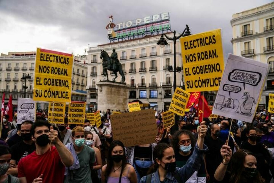 Protester i Madrid i somras mot höga elpriser: 'Elbolagen rånar oss och regeringen är deras medbrottsling', står det bland annat på plakaten. Arkivbild. Foto: Manu Fernandez/AP/TT