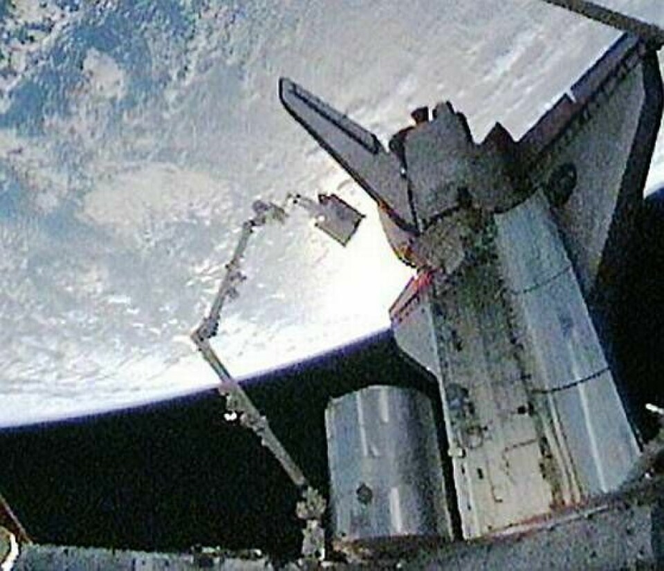 Högst upp i robotarmen på ISS hänger Christer Fuglesang med den 800 kilo tunga ammoniaktanken i sin hand. Foto: Nasa